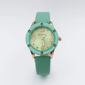 Close-up of mint green vintage quartz watch with rose gold metal case and leather strap