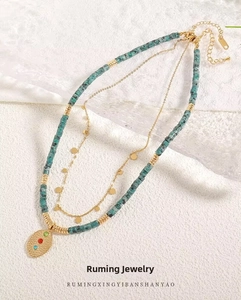 Detail of bohemian layered necklace with turquoise beads and gemstone gold pendant