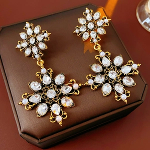 Détails de boucles d'oreilles vintage en or avec fleurs, cristaux et perles fines