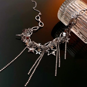 Silver star pendant necklace with rhinestone tassels on a black reflective background