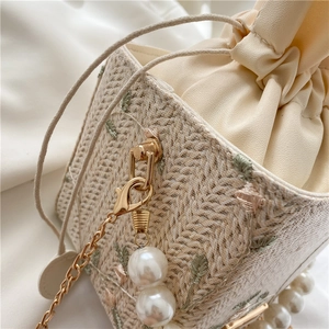 Cream pearl bucket bag with woven straw pattern, floral embroidery and gold chain strap