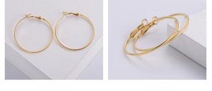 Macro detail of gold plated hoop earrings featuring intricate embossed lattice patterns