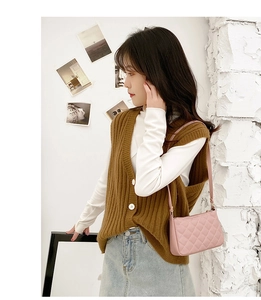 Pink quilted shoulder bag styled with a brown knit vest and casual denim skirt