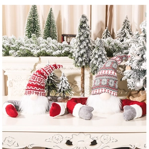 Close-up of plush Christmas gnomes with knit hats on a decorated holiday mantel