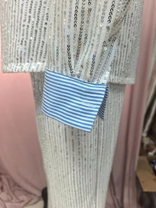 Close-up of silver sequins stitching and blue striped shirt cuffs on a fashion jacket