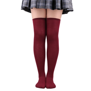Close-up of burgundy three-stripe over-the-knee socks paired with a school uniform skirt