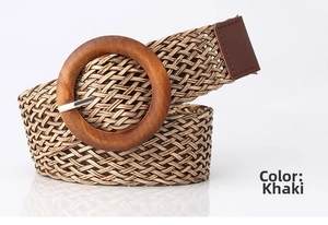 Detail of woven khaki belt featuring a round wooden buckle and fine leather trim details