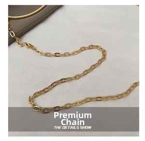 Detail of a shiny gold metallic chain strap with oval links for a fashion evening bag