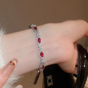 Macro shot of silver bracelet with red oval stones and cubic zirconia accents