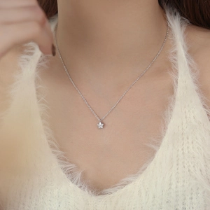 Elegant S999 sterling silver star pendant necklace on a model with a cozy knit sweater