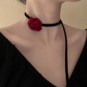 Detail shot of a red fabric rose choker with long black ribbon ties on a model