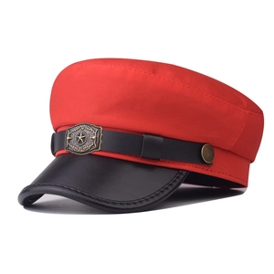 Detailed view of the star badge and black leather brim on this red military cap