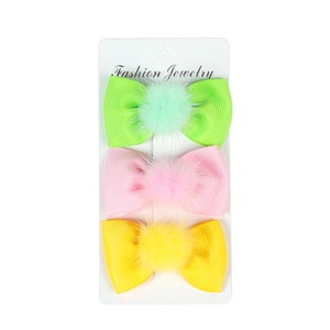 Three-piece set of girls' grosgrain bow hair clips with plush pom-poms on display card