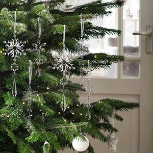 Detail of transparent acrylic snowflake and icicle ornaments with silver ribbons for tree deco