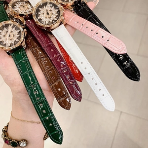 Close-up of stylish leather watches with rotating flower dials and rose gold details