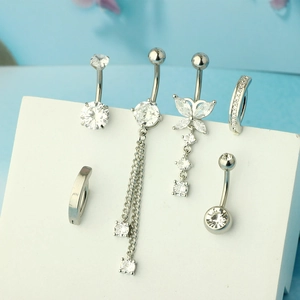 Set of 6 silver stainless steel belly rings with butterfly and zircon stones on a blue stand