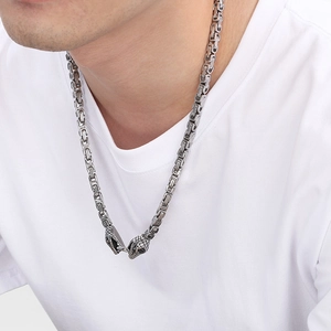 Close-up of men's silver Byzantine chain necklace with vintage double snake head clasps