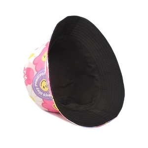 Detail view of double-sided bucket hat with pink floral print and yellow smiley face pattern