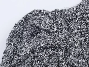 Gros plan sur un tissu en maille chiné noir et blanc montrant une texture tissée et épaisse