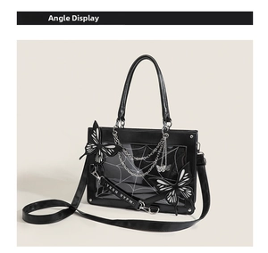 Detail view of gothic ita bag featuring spiderweb window and metallic butterfly chains