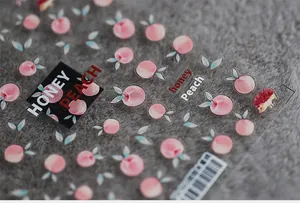 Detailed view of honey peach and hedgehog nail art stickers on a soft plush background
