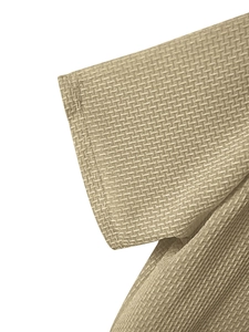 Macro shot of breathable waffle knit texture and seam detail on light khaki t-shirt sleeve