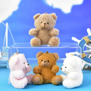 Assorted small curly fur teddy bear plush keychains displayed in a nautical setting