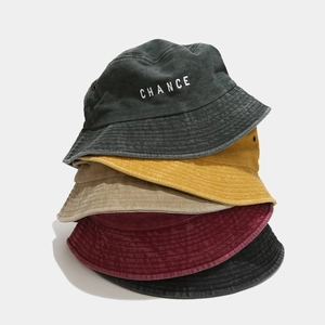 Detailed view of stacked vintage washed cotton bucket hats in five assorted colors with embroidery