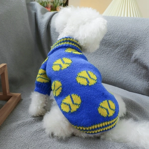 Close-up of blue pet knit sweater with yellow tennis patterns on grey sofa background