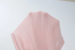 Close-up of pink sheer breathable fabric showing detailed knit texture and transparency