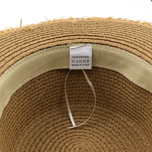 Inside view of a foldable straw sun hat with 100% paper tag and white sweatband