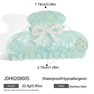 Detail view of acetate hair claw with white glitter bow and size measurements
