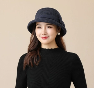 Detailed view of women's dark blue houndstooth bucket hat with elegant rolled brim