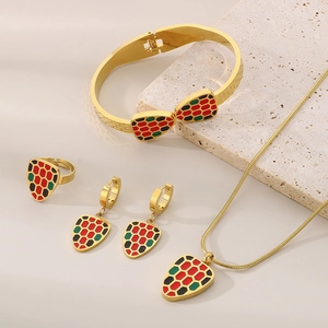 Flat lay of colorful enamel snake head jewelry set including necklace and earrings