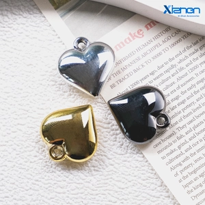 Macro detail of heart-shaped acrylic pendants in silver, gold, and gunmetal metallic finish