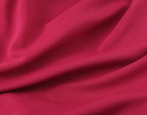 Dettaglio del tessuto dell'abito rosso rosa scuro con trama morbida e trama fitta