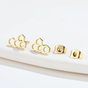 Detail view of golden honeycomb hollow hexagon stud earrings with butterfly backings