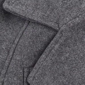 Close-up of grey wool coat showing high-quality fabric texture and detailed stitching