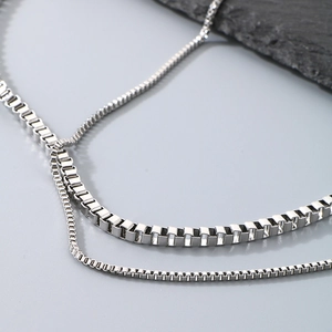 Macro shot of silver stainless steel box chain necklace with high polish finish