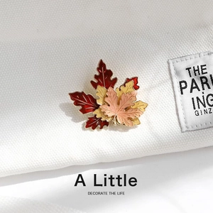Elegant multi-color layered maple leaf brooch with enamel finish on white fabric