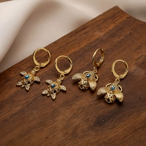 Gold-plated bee and turtle earrings with blue evil eye detail and clear rhinestones