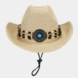 Detail of western straw hat featuring ethnic beaded band and turquoise metal ornament