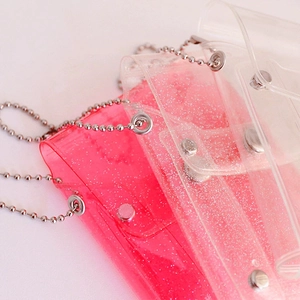 Detail of pink and clear glitter PVC mini card holder with metal chain strap