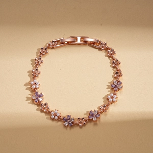 Close-up of rose gold floral bracelet with white pearls and purple zircon stones