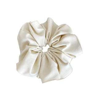 Chouchou en similicuir beige crème avec texture plissée douce sur fond blanc