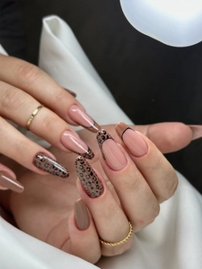 Macro detail of long almond nails with leopard print and French tips in nude tones