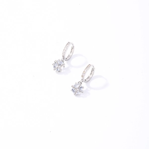 Macro détaillée de boucles d'oreilles flocon en argent avec des pierres de zircone