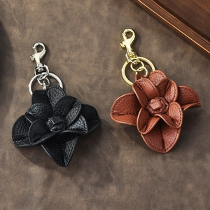 Faux leather camellia flower keychains in black and brown with metal ring and clasp