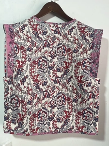 Rear view detail of a white quilted vest featuring vintage ethnic floral print patterns