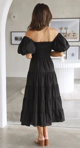 Detail of puff sleeves and elastic shirred back on a black off-shoulder midi dress